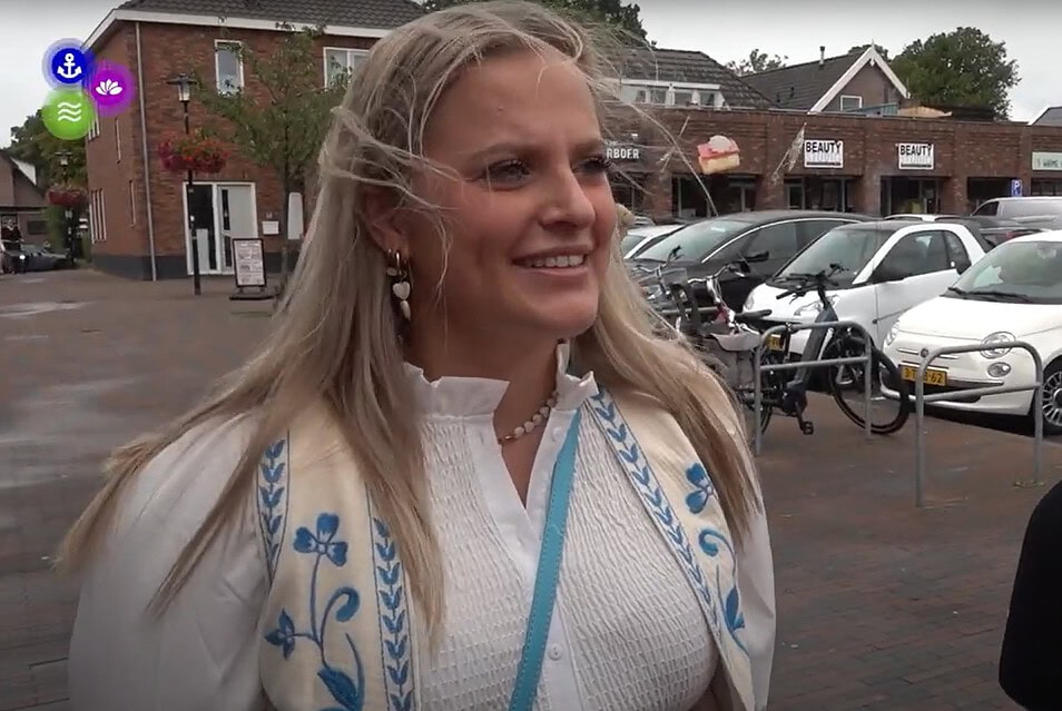 vrouw met blond haar die geinterviewd word op straat bij een winkelcentrum