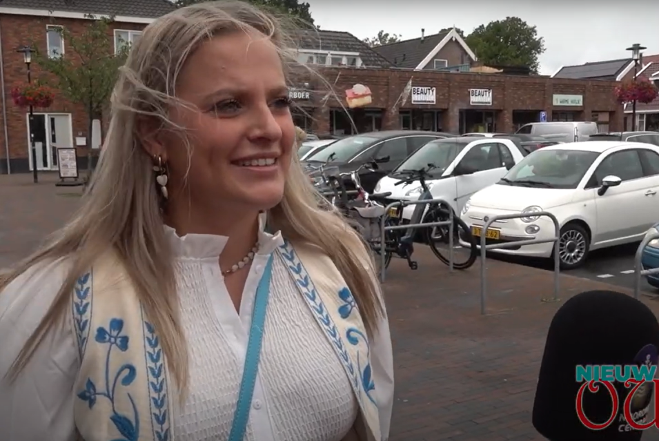 vrouw met blond haar die geinterviewd word op straat bij een winkelcentrum